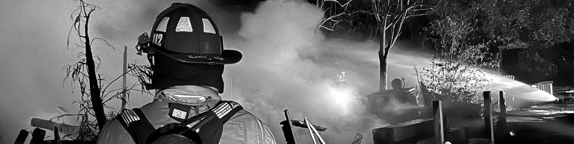 firefighter looking at massive firehose spray
